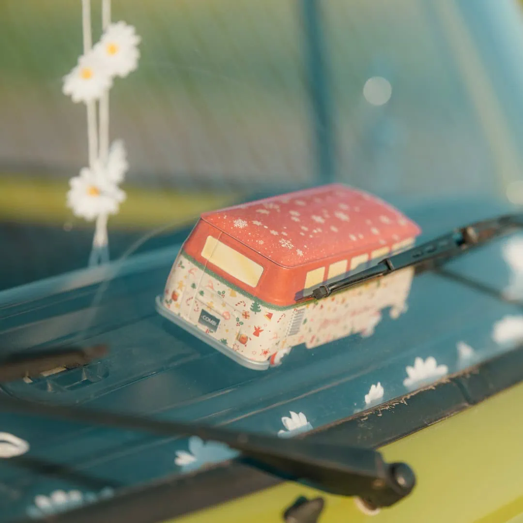 Kleiner Spielzeug-Bulli auf dem Armaturenbrett des Fotobus mit Gänseblümchen-Deko.
