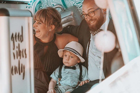 Familie mit kleinem Jungen sitzt eng beieinander im gemieteten Fotobulli.